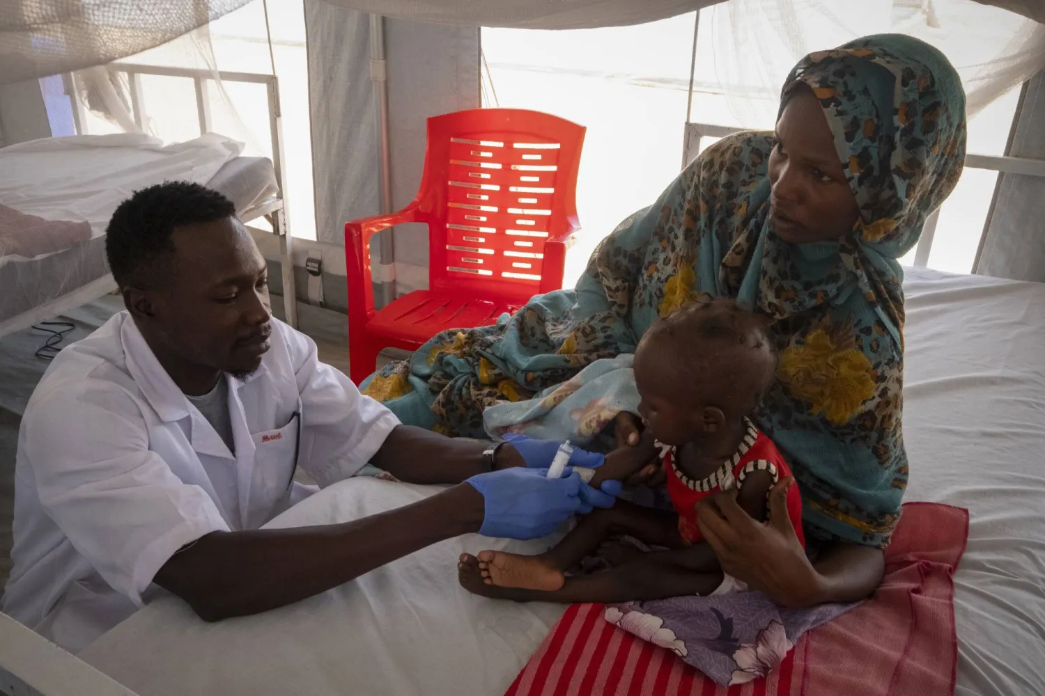 A refugee mother from Darfur in Sudan holds her son during his medical exam, at the hospital set up by the NGO Doctors Without Borders (MSF) in the refugee camp of Metche, eastern Chad, 05 April 2024. EPA/STRINGER