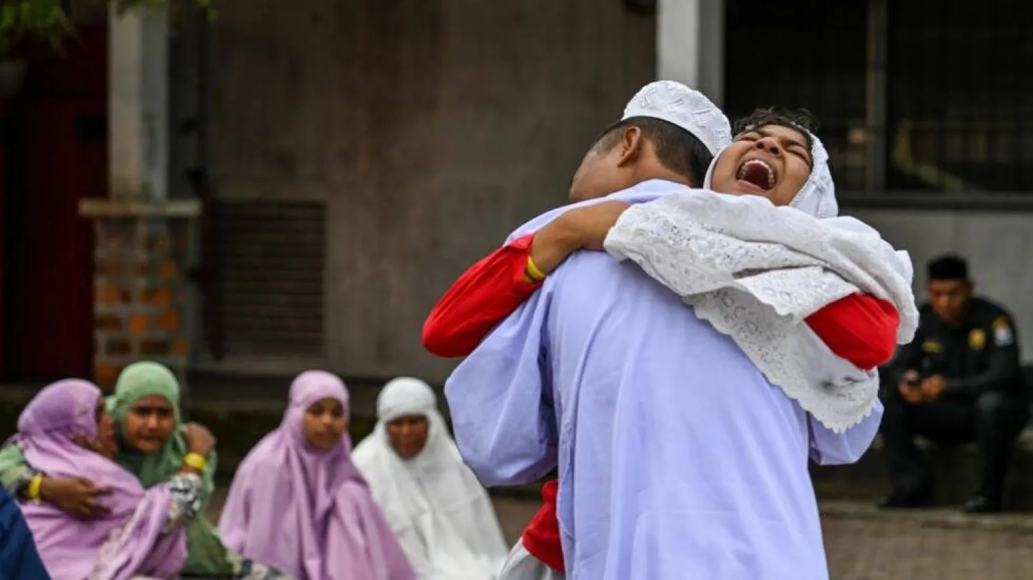 Rohingya refugees embrace each other after taking part in Eid al-Fitr prayers. CHAIDEER MAHYUDDIN / AFP
