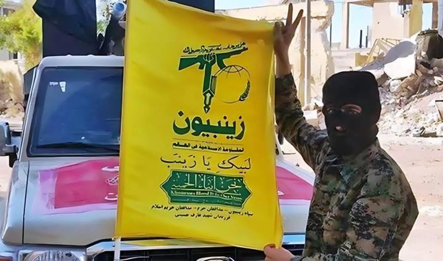 مقاتلون شيعة باكستانيون يحملون راية كتيبة «زينبيون»... (متداولة)