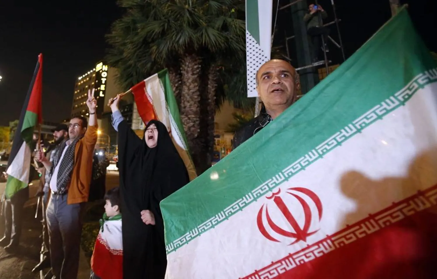People hold Iranian and Palestinian flags during an anti-Israel rally after Iran launched drone attacks against Israel at Palestine Square in Tehran, Iran, early morning of 14 April 2024. (EPA)