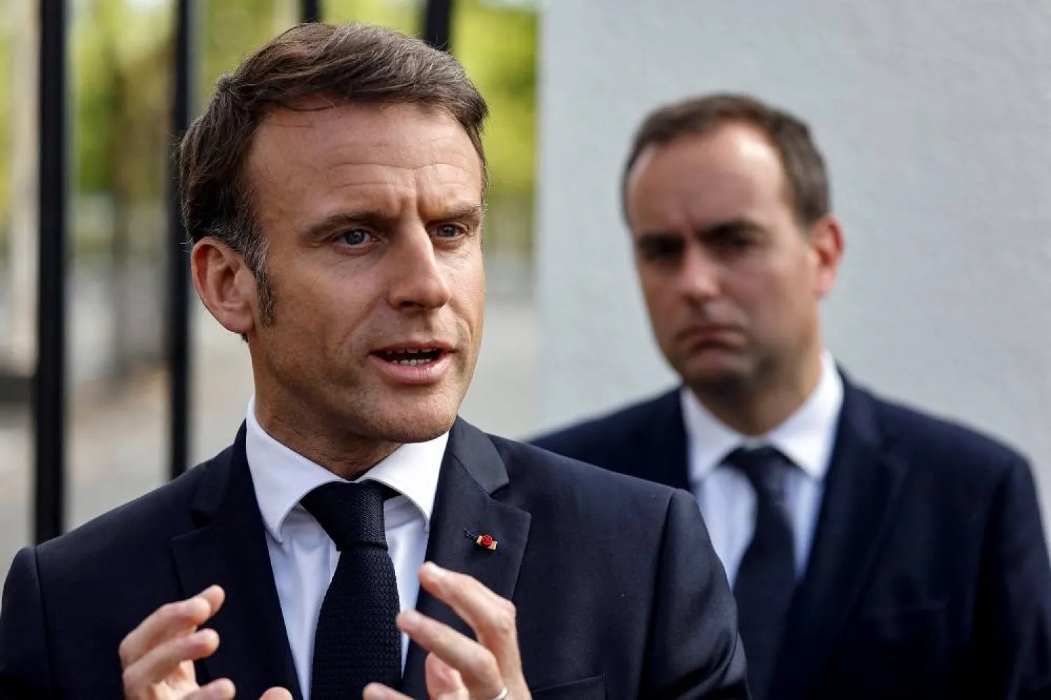 France's President Emmanuel Macron addresses the media as France's Minister for the Armed Forces Sebastien Lecornu listens during a visit to the powders and explosives company Eurenco plant in Bergerac, southwestern France, on April 11, 2024. (Reuters)
