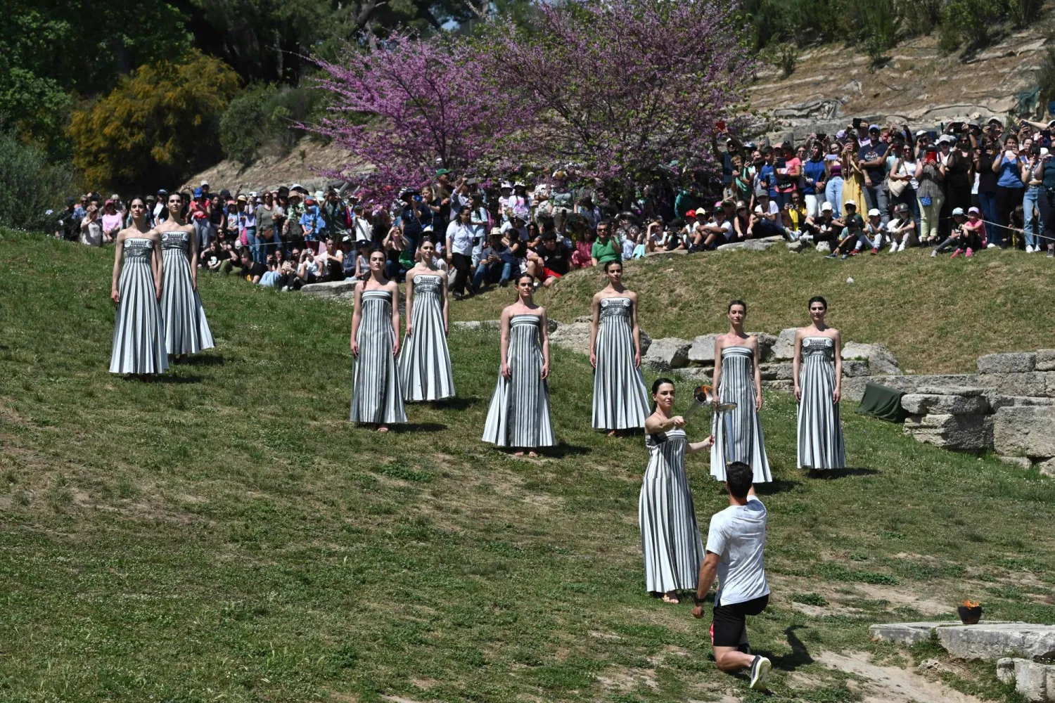 الممثلة اليونانية ماري مينا تشعل شعلة أولمبياد باريس 2024 من قِبل حامل الشعلة الأول (أ.ف.ب)