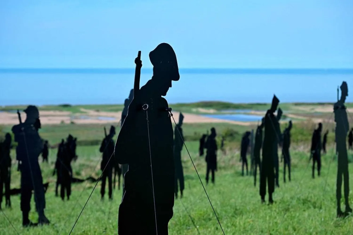 This photograph taken on April 12, 2024 shows cutting board silhouettes of British soldiers installed as part of the "Standing with Giants" installation at the World War II British Normandy Memorial ahead of the upcoming D-Day commemorations, in the village of Ver-sur-Mer which overlooks the Gold Beach in northwestern France. (AFP)  