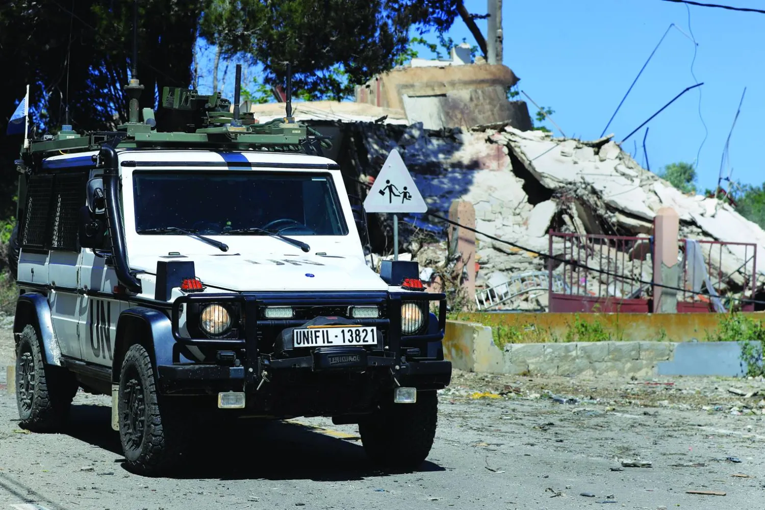 A vehicle of the United Nations peacekeeping forces, moves past a destroyed house that was hit by an Israeli airstrike, in Alma al-Shaab, a Lebanese border village with Israel, south Lebanon, Wednesday, April 17, 2024. (AP Photo/Mohammed Zaatari)