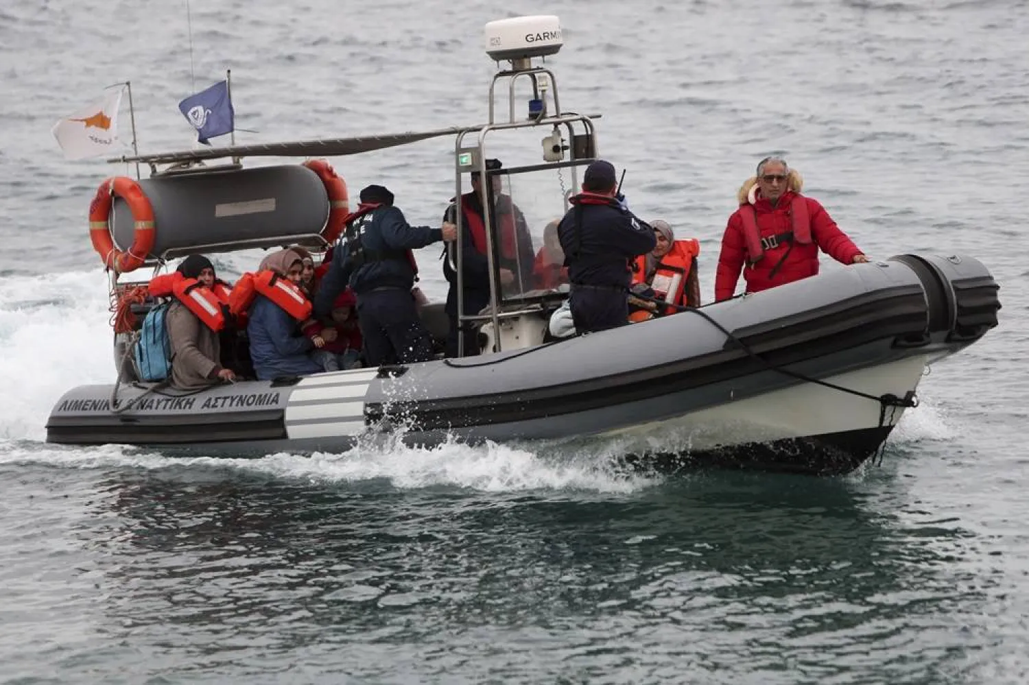 Migrants sit on a Cyprus marine police boat as they are brought to a harbor after being rescued from their own vessel off the Mediterranean island nation's southeastern coast of Protaras, Cyprus, on Jan. 14, 2020. (AP)