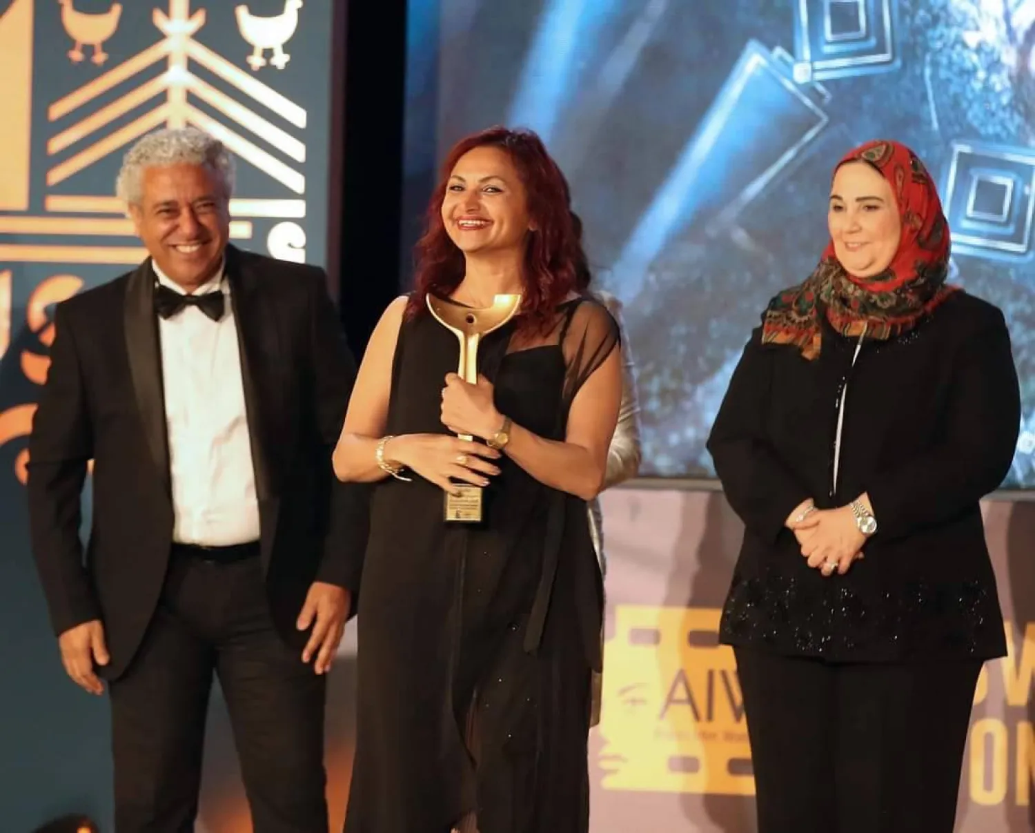 خليل بين وزيرة التضامن ورئيس المهرجان خلال تكريمها بأسوان (أسوان السينمائي لأفلام المرأة)  

