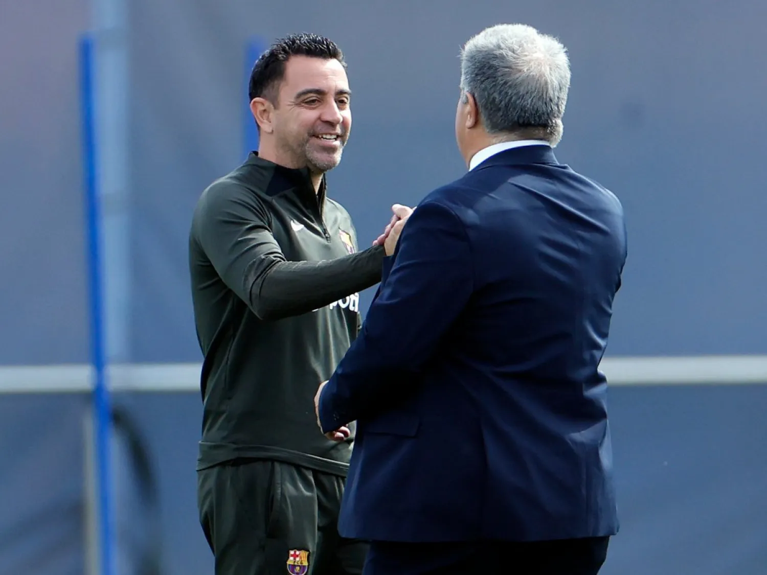تشافي هرنانديز مدرب برشلونة يصافح خوان لابورتا رئيس النادي خلال تدريبات سابقة (إ.ب.أ)