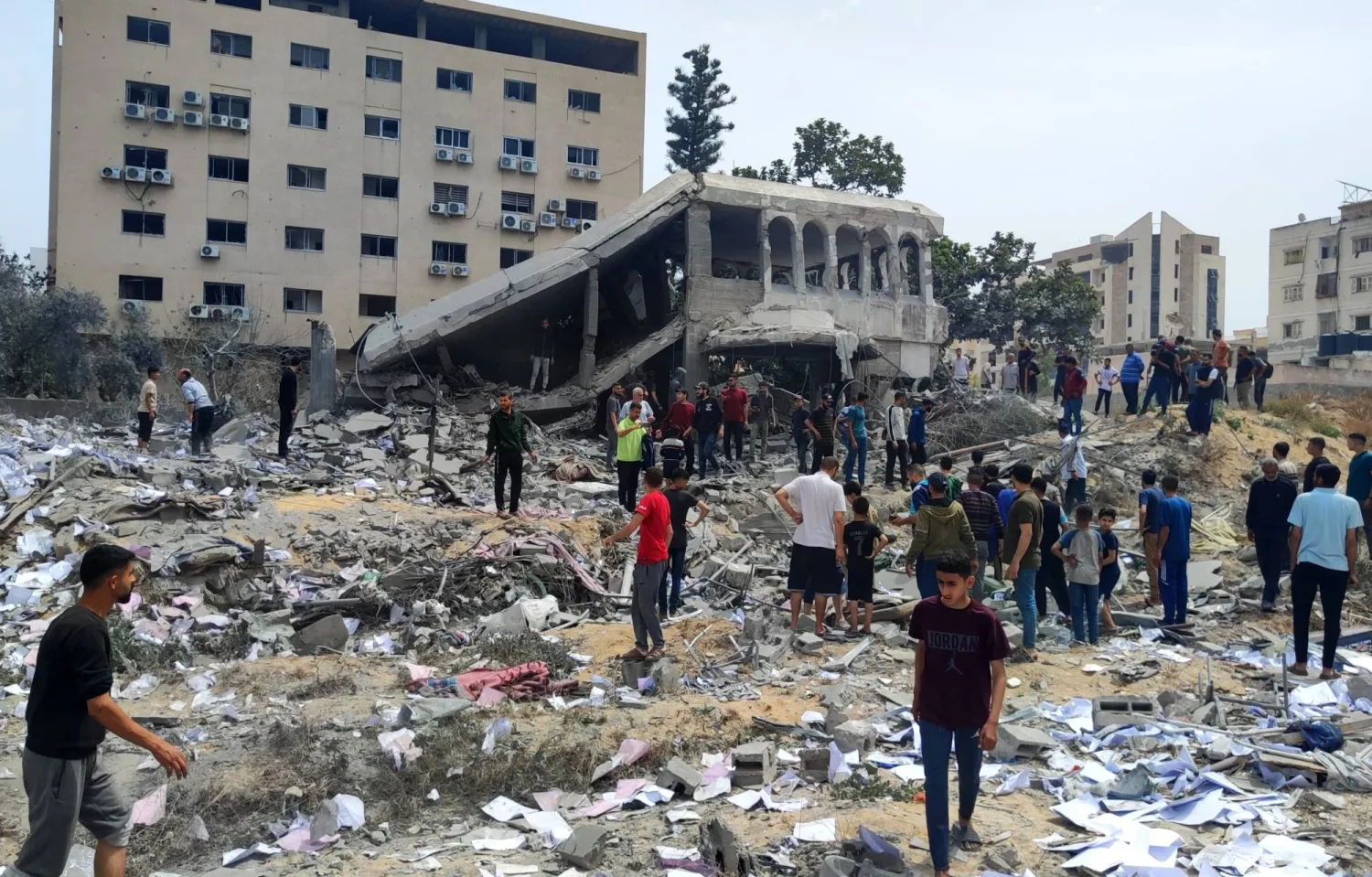 فلسطينيون يتفقدون منزلاً دمرته غارية إسرائيلية على مدينة غزة (د.ب.أ)