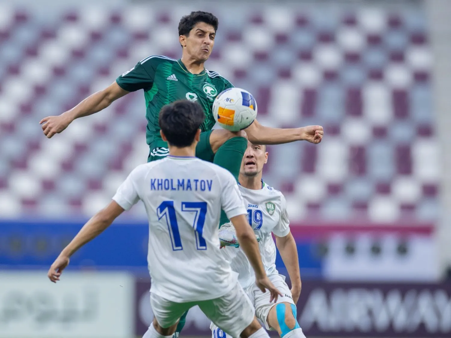 فيصل الغامدي في كرة مشتركة مع لاعب أوزبكستان (المنتخب السعودي)