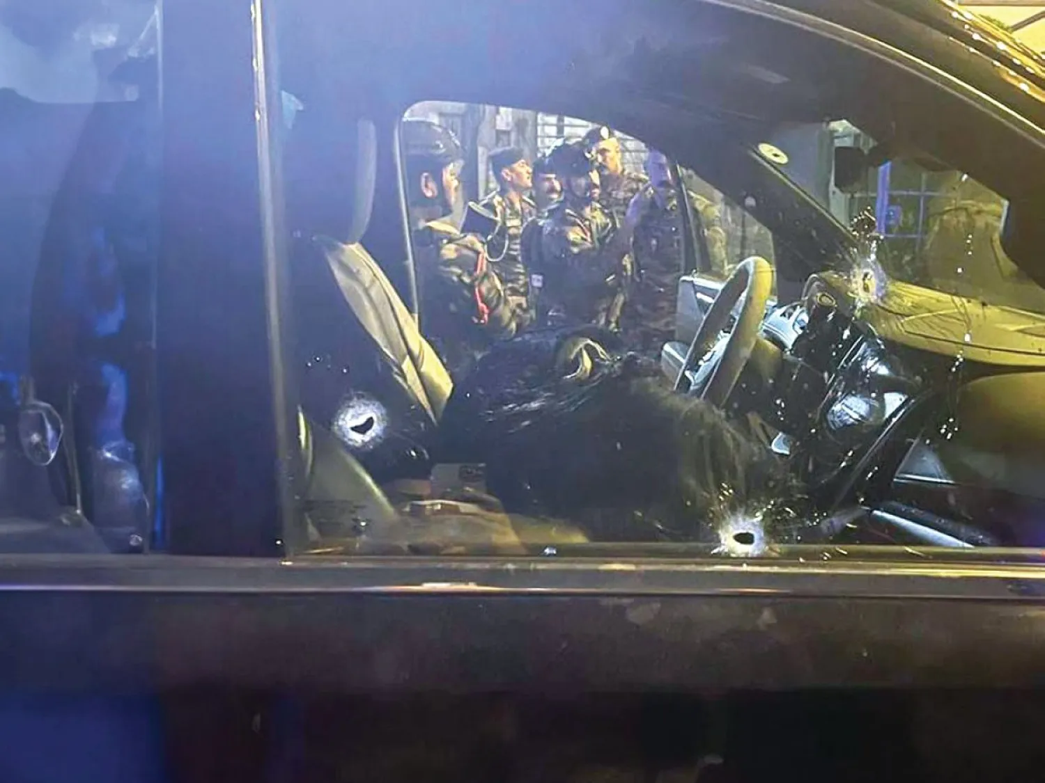 
عناصر من الشرطة العراقية يحيطون بسيارة «أم فهد» بعد اغتيالها وسط بغداد (إكس)