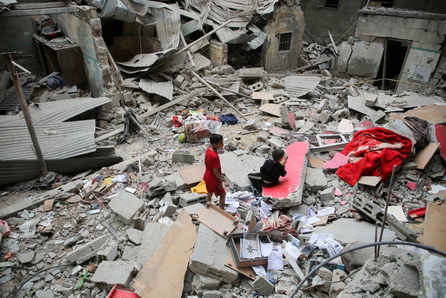 FILE PHOTO: Palestinian children inspect the site of an Israeli strike on a house, amid the ongoing conflict between Israel and the Palestinian group Hamas, in Rafah, in the southern Gaza Strip, April 27, 2024. REUTERS/Hatem Khaled/