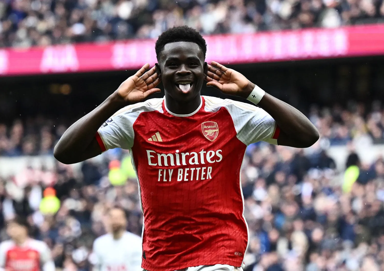 ساكا فرحاً عقب تسجيله هدف آرسنال الثاني في مرمى توتنهام هوتسبير في الدوري الإنجليزي (رويترز)