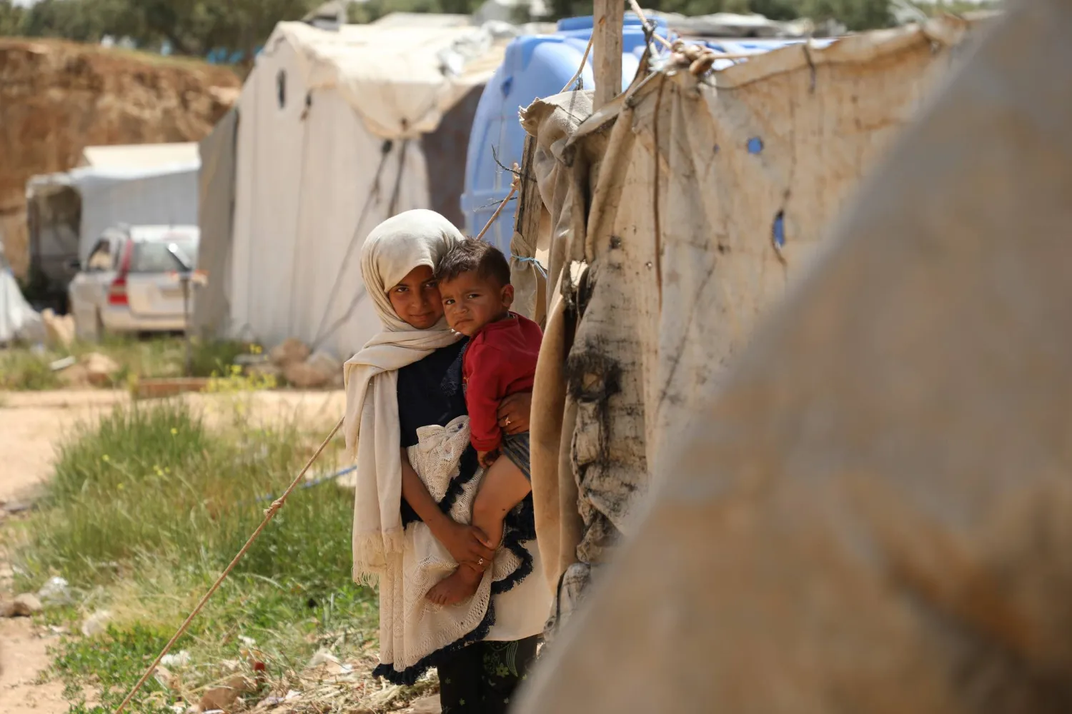 طفلة وشقيقها المولود في مخيم «الإيمان» العشوائي (الشرق الأوسط)