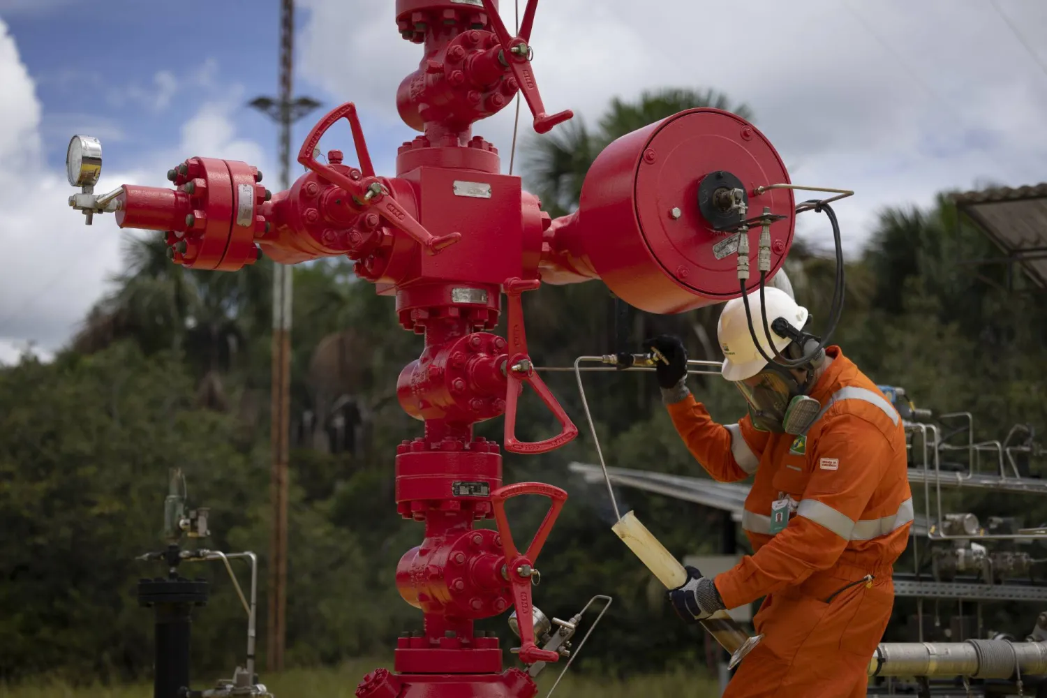 أحد موظفي «بتروبراس» يأخذ عينة زيت من بئر تم اكتشافه في منطقة أوروكو النفطية في كواري أمازوناس بالبرازيل (إي. بي أي)