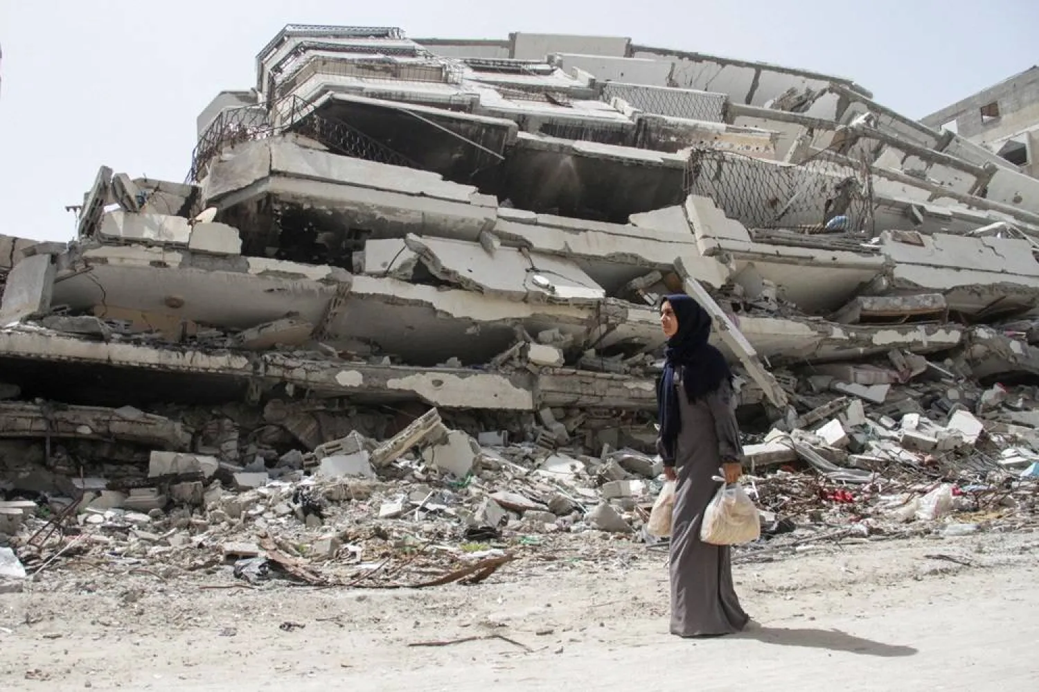  Palestinian woman Asmaa Al-Belbasi, making her way back to her shelter after buying bread from recently reopened Al-Sharq bakery, walks past the ruins of a house destroyed during Israel's military offensive, amid the ongoing conflict between Israel and Hamas, in Gaza City April 24, 2024. (Reuters)