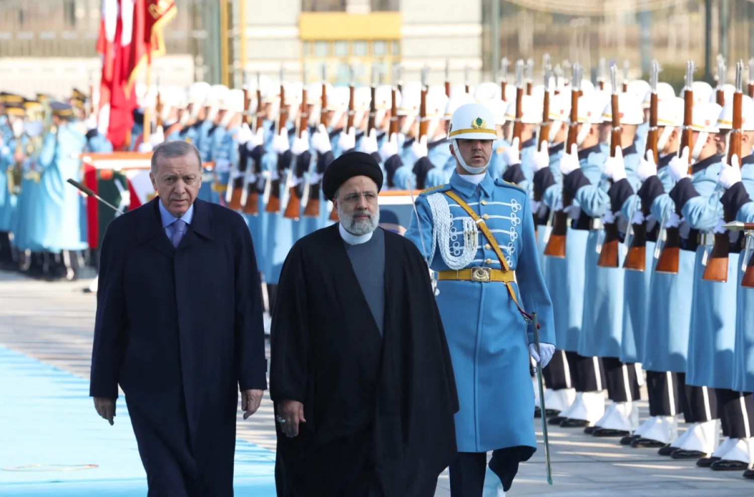 Cumhurbaşkanı Recep Tayyip Erdoğan (solda) ve İran'ın merhum Cumhurbaşkanı İbrahim Reisi (sağda) Ankara'da düzenlenen karşılama töreninde şeref kıtasını selamlarken, 24 Ocak 2024 (AFP)