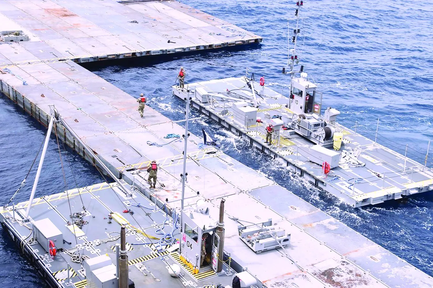 
صورة غير مؤرخة نشرتها قيادة «سنتكوم» الأميركية أمس تظهر رصيفاً عائماً قبالة قطاع غزة في إطار مساعي إنشاء ميناء لإيصال المساعدات (أ.ب)