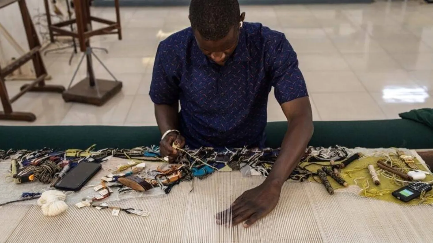Senegalese tapestries adorn the walls of organizations the world over. JOHN WESSELS / AFP
