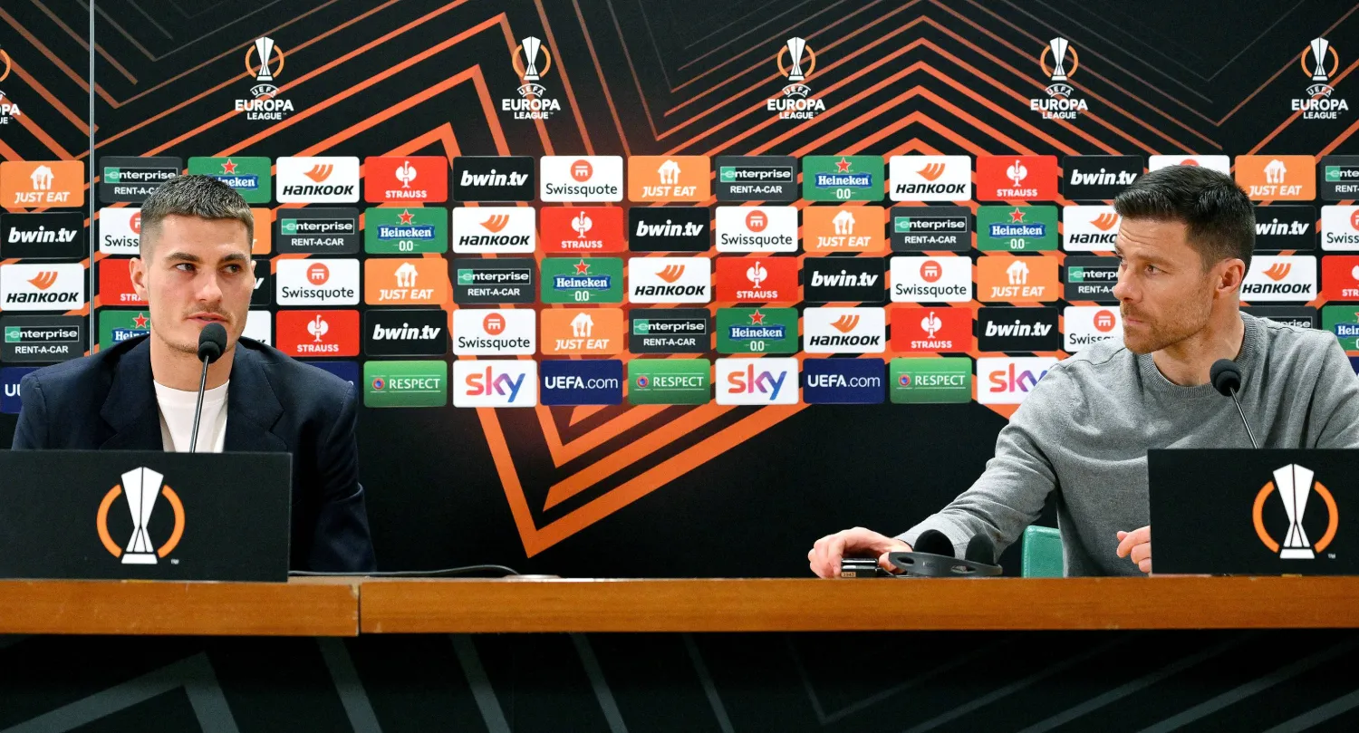 ألونسو مدرب ليفركوزن يستمع لحديث مهاجم الفريق باتريك شيك خلال المؤتمر الصحفي (إ.ب.أ)