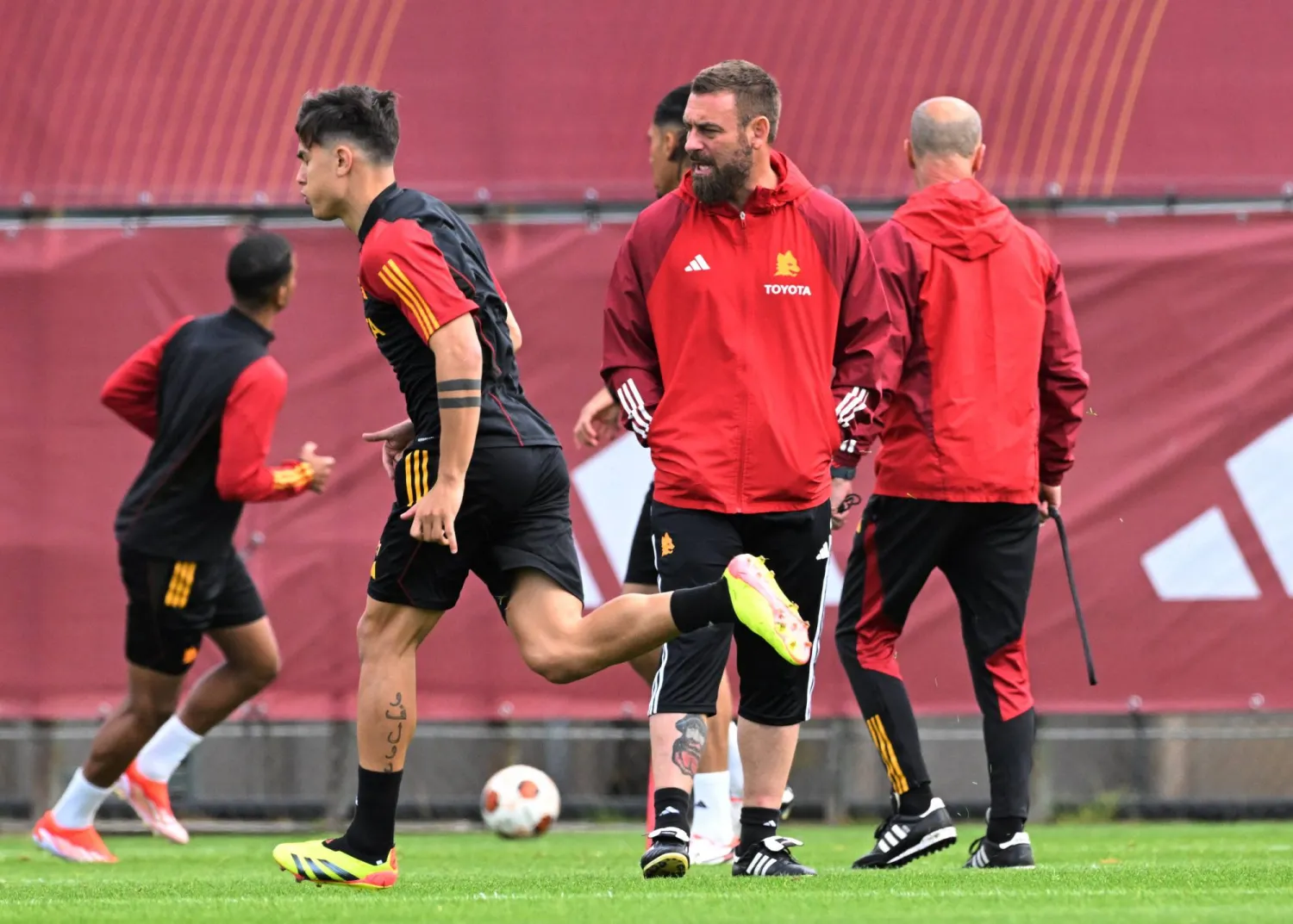 دي روسي يراقب لاعبي روما خلال التدريبات آملاً في نصر جديد على ليفركوزن (رويترز)