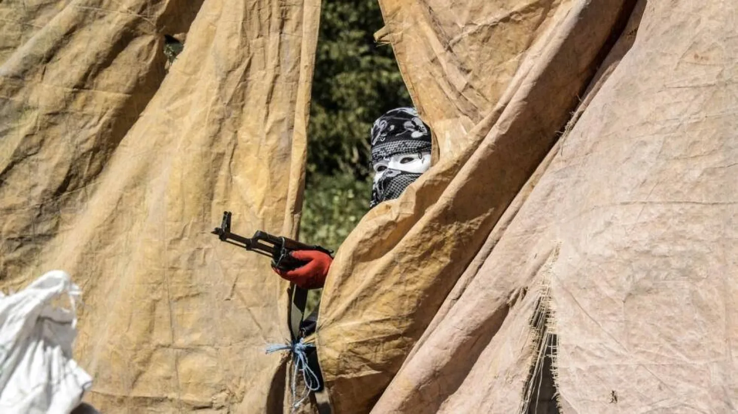 An armed Kurdish militant of the Kurdistan Workers' Party (PKK) wearing a mask and a scarf covering his head aims his weapon in Diyarbakir in September 2015. (AFP)