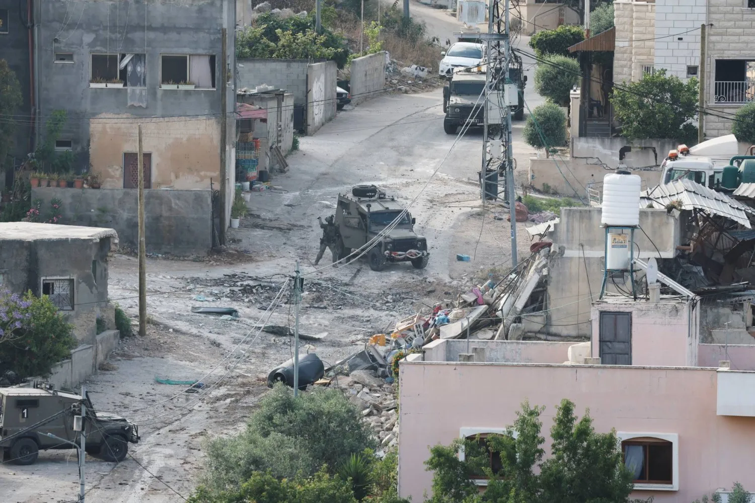 Batı Şeria'nın Deyr el-Ğasun beldesinde askeri aracın yanında duran bir İsrail askeri (Reuters)