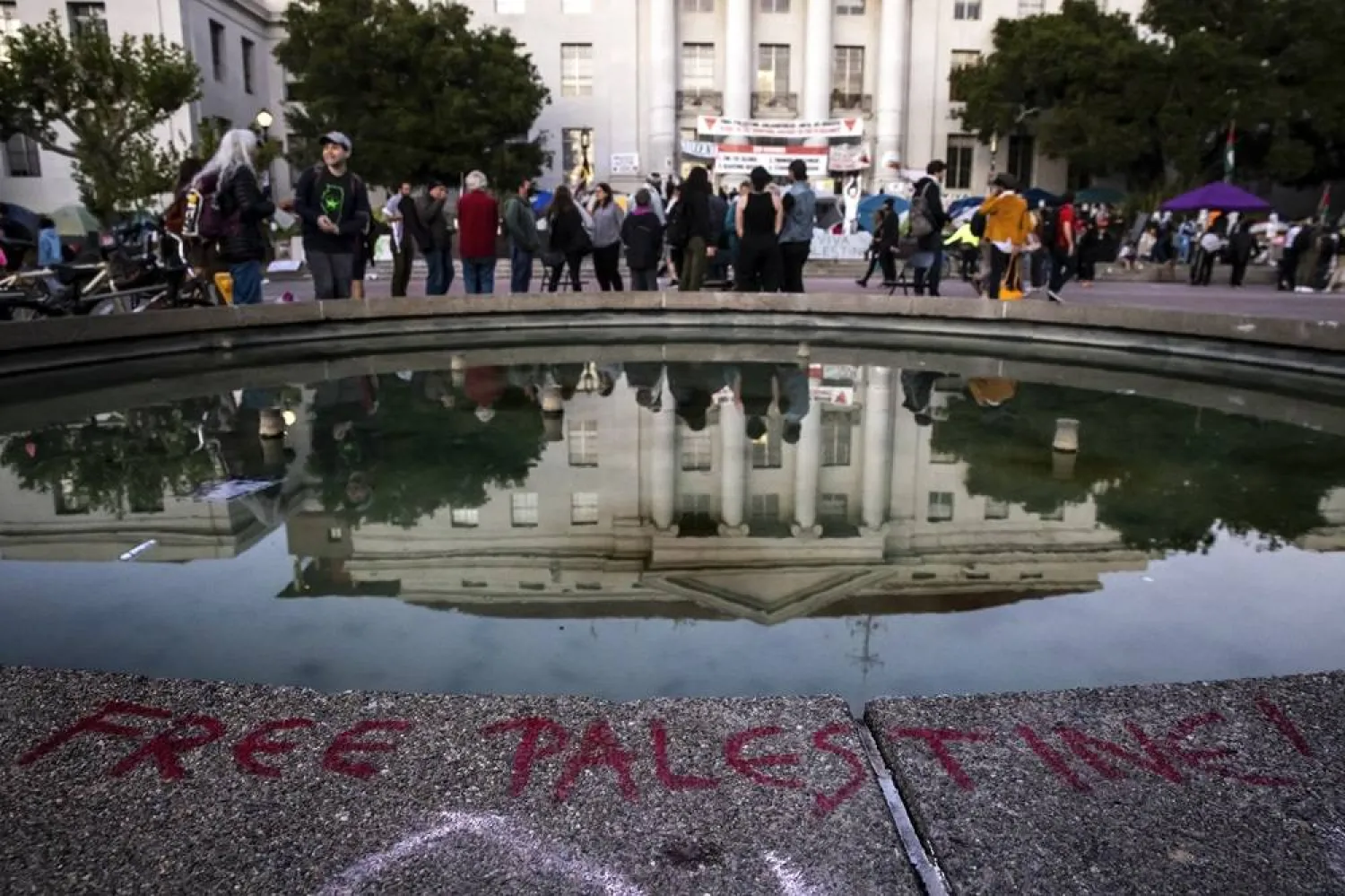 A message saying "Free Palestine!" is written on the rim of Ludwig's Fountain where a pro-Palestinian tent encampment remains on the steps of Sproul Hall at University of California, Berkeley in Berkeley, Calif., on Thursday, May 2, 2024. (San Francisco Chronicle via AP)