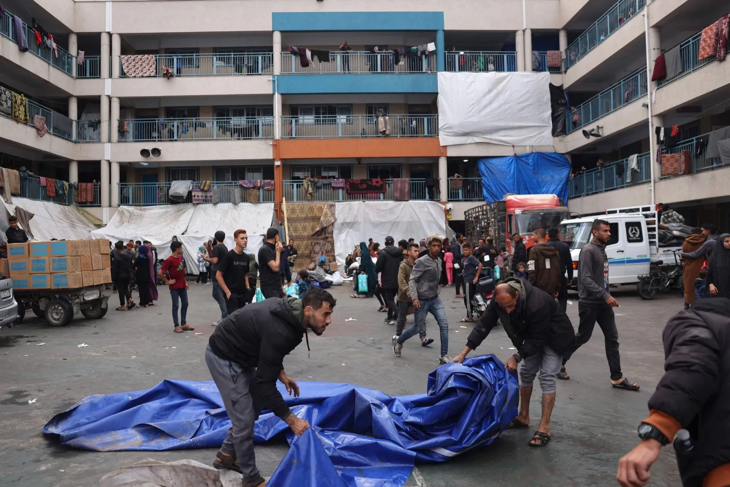 فلسطينيون يحاولون فك الخيام وأخدها معهم قبل النزوح من رفح (أ.ف.ب)