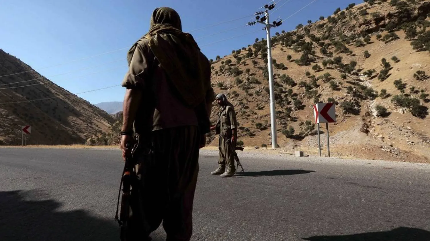 A member of the PKK carries an automatic rifle on a road in the Qandil Mountains in northern Iraq, 22 June 2018 (AFP)