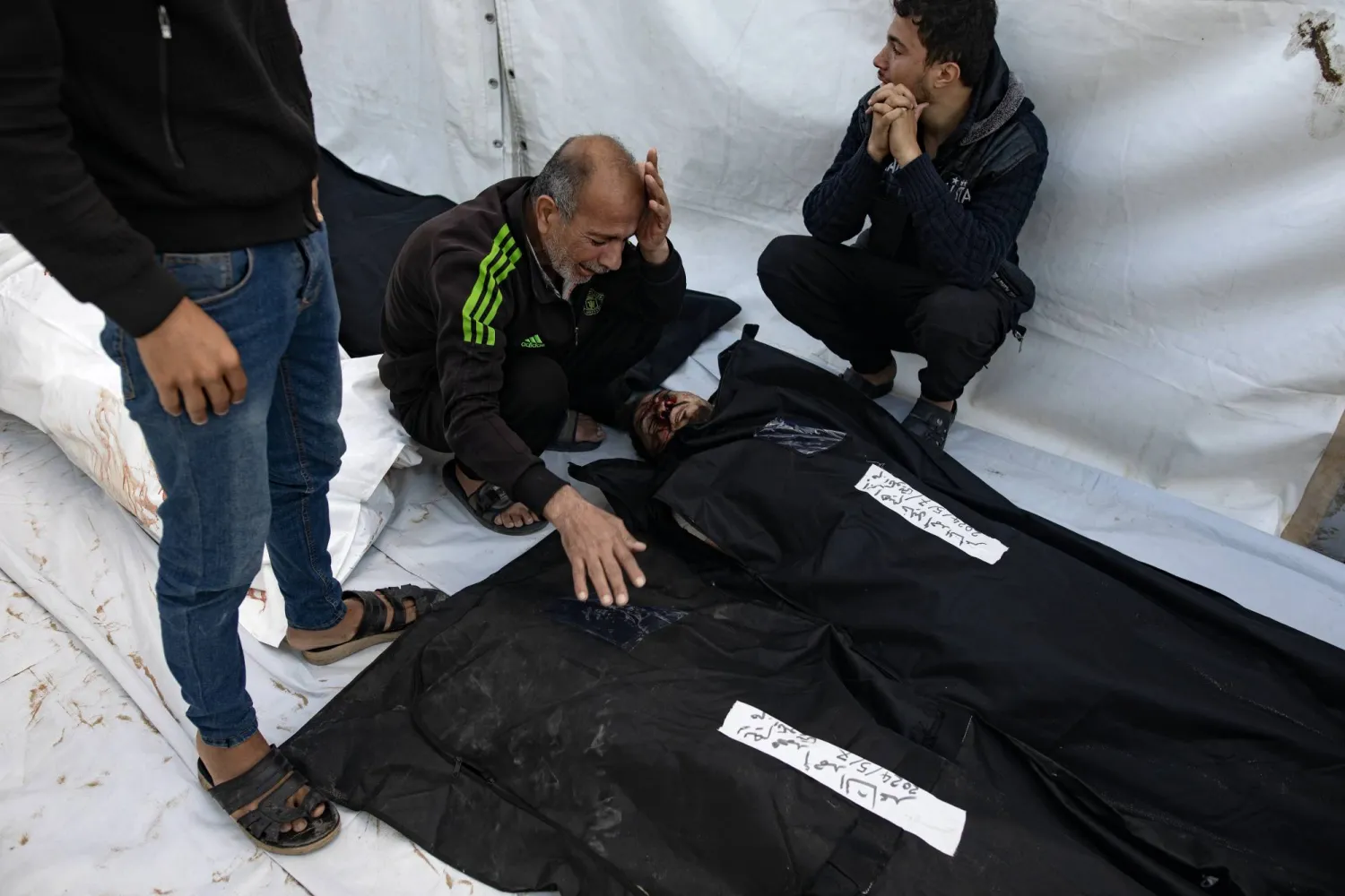 أقارب الفلسطينيين الذين قُتلوا خلال الغارات الجوية الإسرائيلية خلال الليل على مخيم رفح للاجئين ينعون ضحاياهم خارج مستشفى رفح الميداني في رفح (إ.ب.أ)