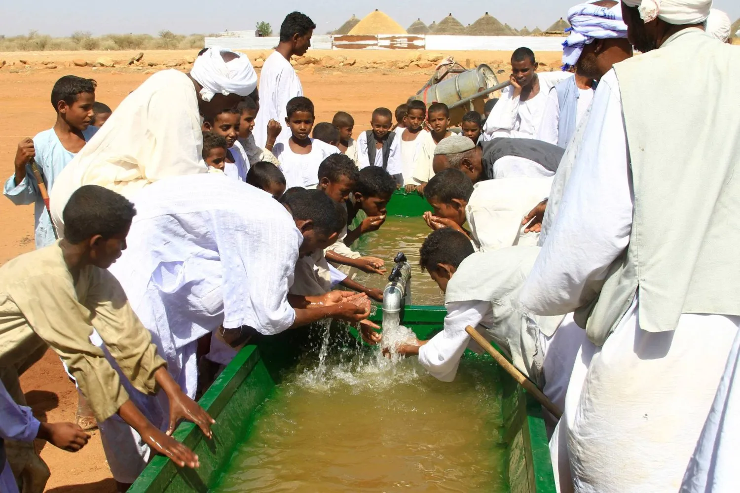 Sudan'ın doğusunda bulunan el-Gadarif eyaletindeki bir yeraltı kuyusundan çıkarılan suyu içen Sudanlılar (AFP)