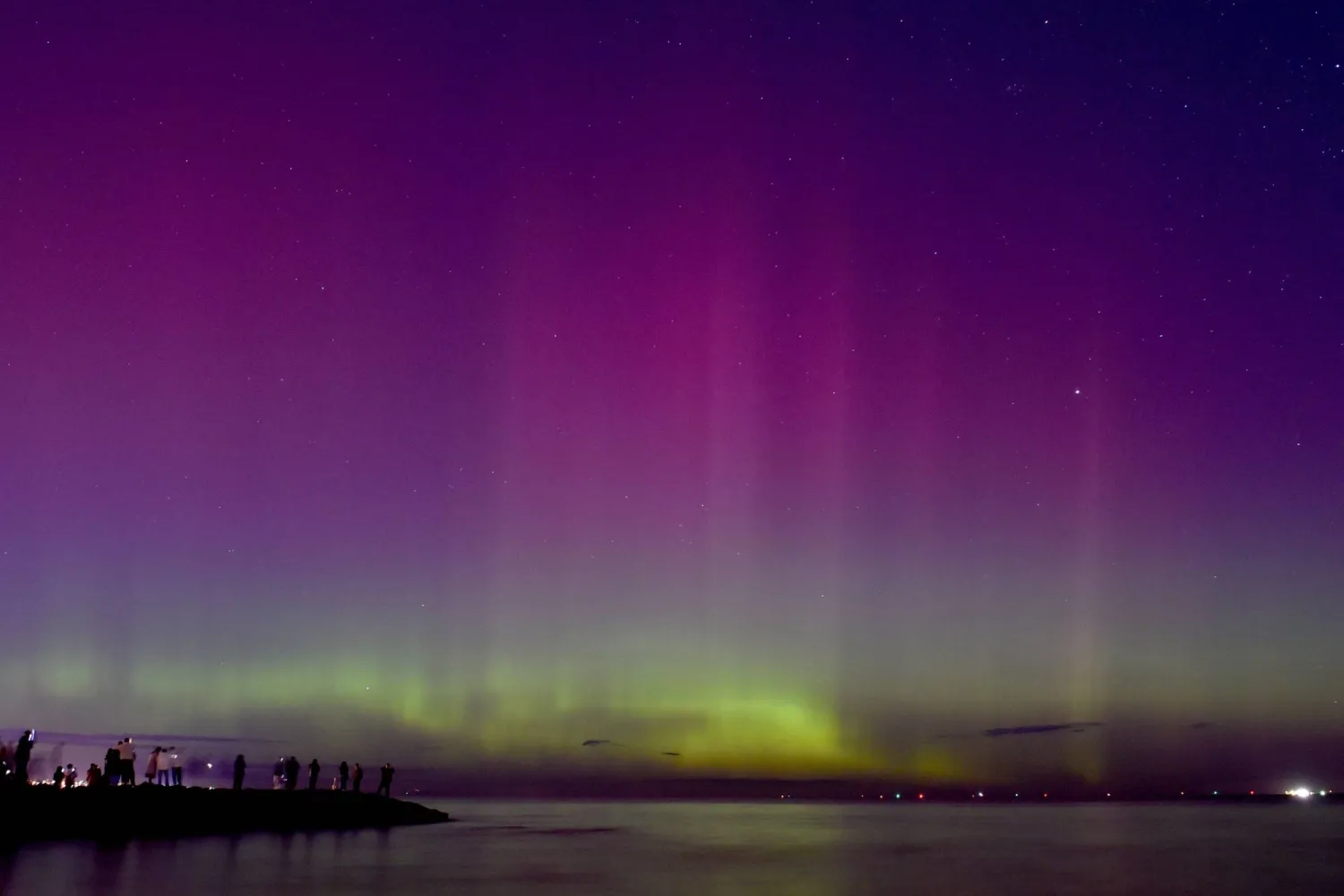 الناس يشاهدون الشفق القطبي أو الأضواء الجنوبية في ملبورن (أ.ف.ب)