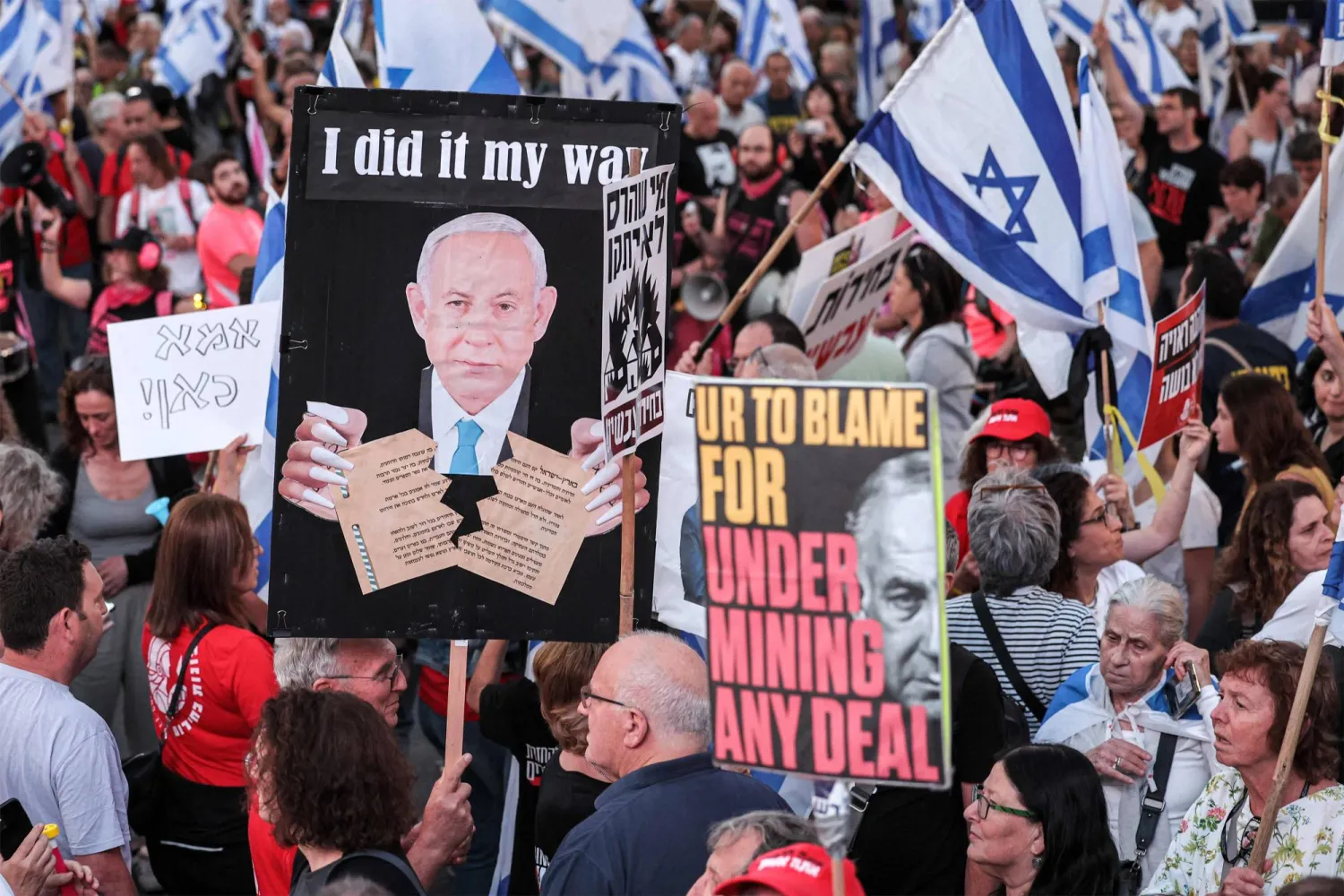 نشطاء يساريون في مظاهرة مناهضة للحكومة ورئيسها في تل أبيب (أ.ف.ب)