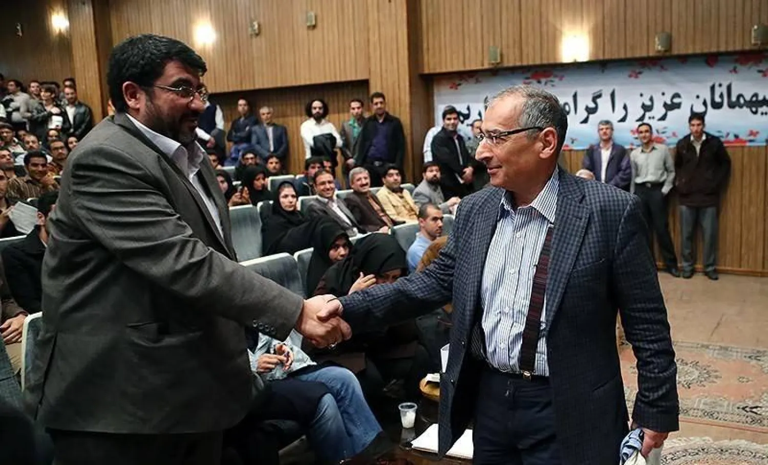 زيبا كلام يصافح المنظر المقرب من «الحرس الثوري» فؤاد إيزدي في جامعة طهران (تسنيم)