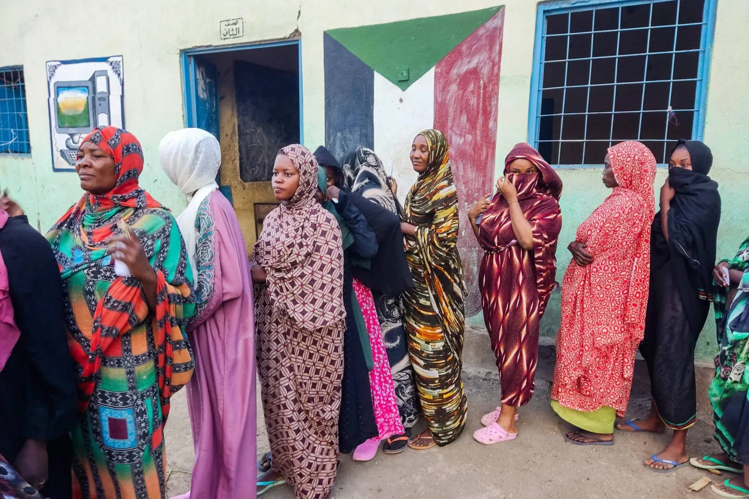 Internally displaced women wait in a queue to collect aid from a group at a camp in Gadaref on May 12, 2024. (Photo by AFP)
