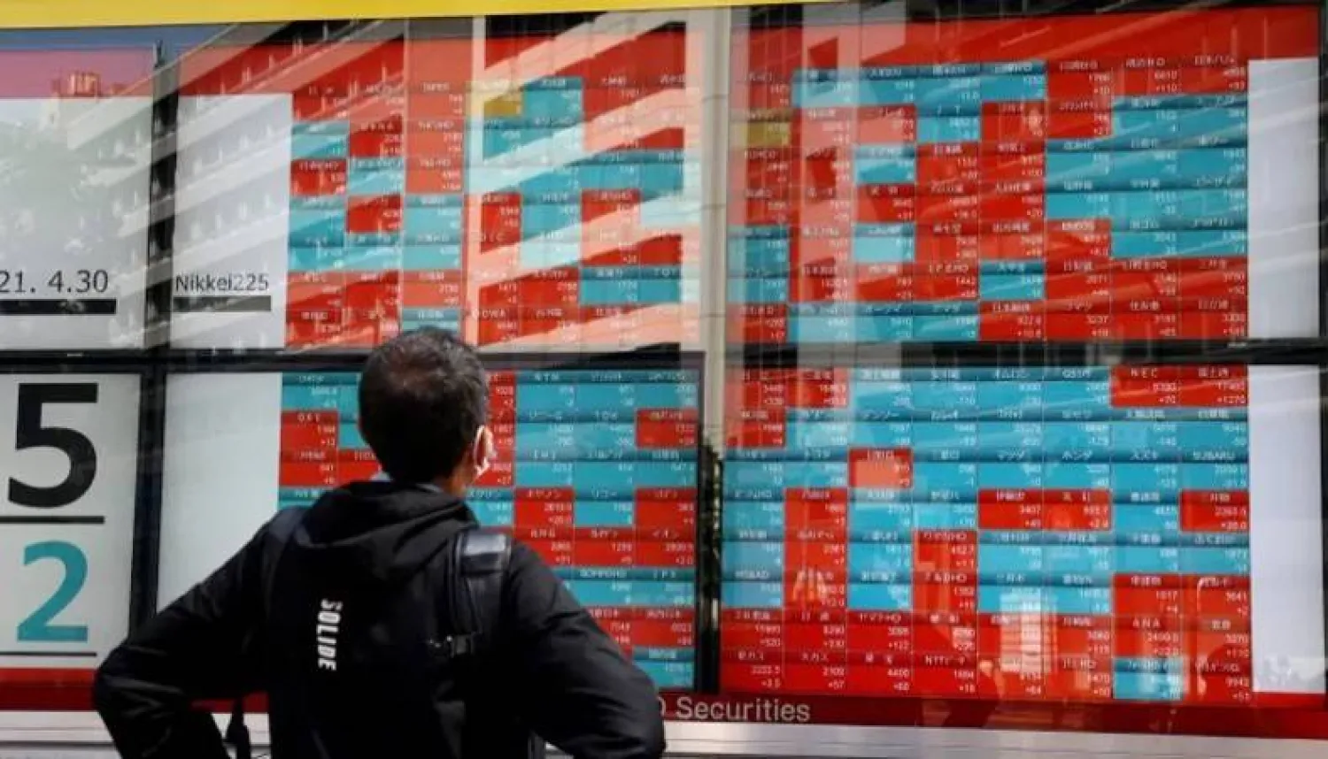 ياباني يتابع حركة الأسهم على مؤشر «نيكي» وسط موسم نتائج الشركات (أ.ف.ب)