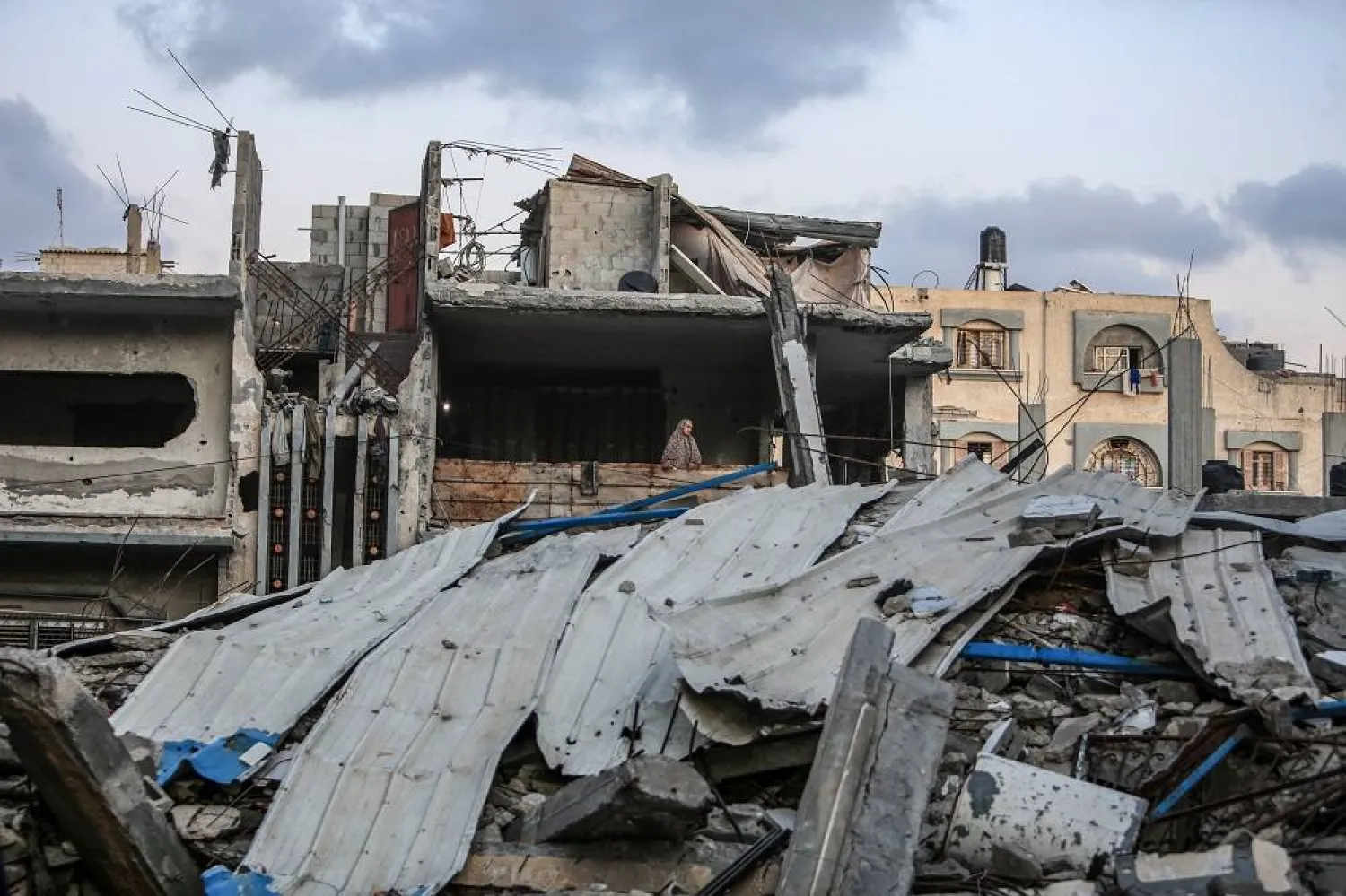 14 May 2024, Palestinian Territories, Deir al-Balah: A displaced Palestinian woman from the city of Rafah fleeing the fighting stands in a building destroyed by Israeli warplanes, in light of the continuing violent fighting between Israel and Hamas. (dpa) 
