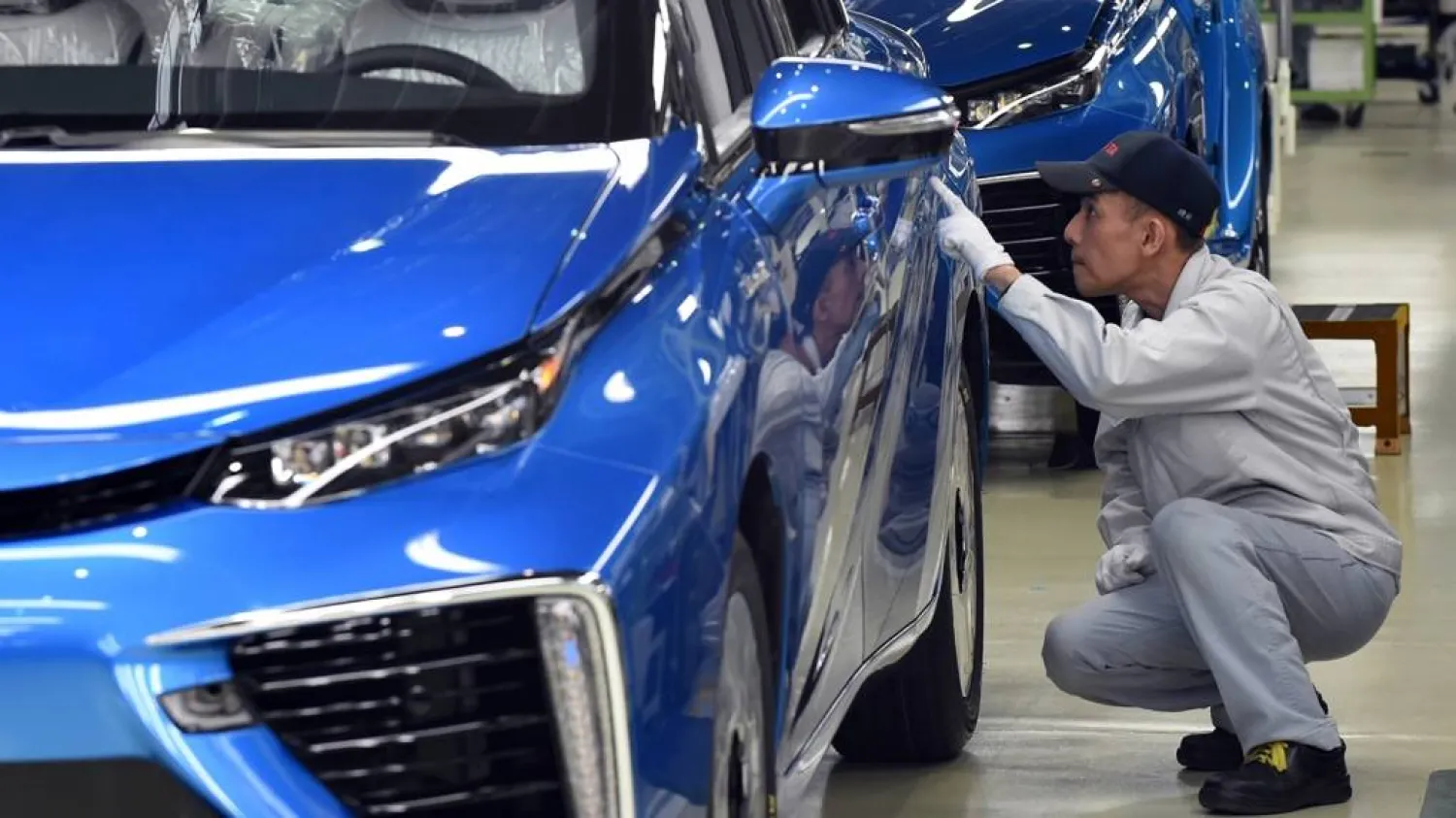 عامل يفحص سيارة في أحد مصانع شركة «تويوتا» اليابانية (أ.ف.ب)