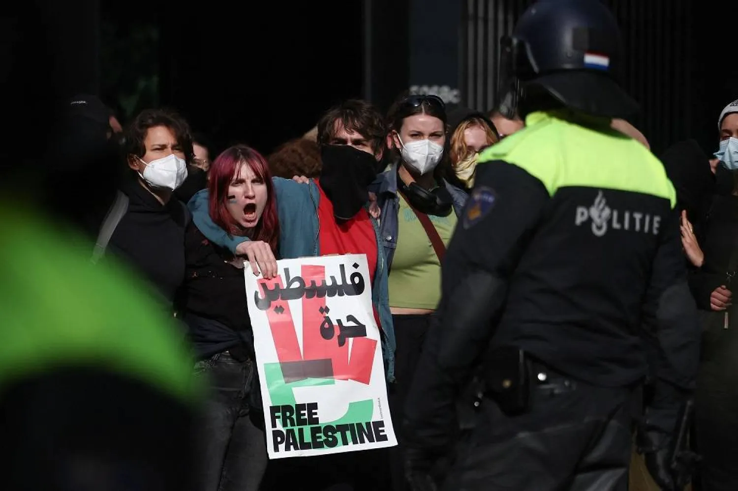 Protesters stand in front of a police officer during a pro-Palestinian demonstration outside Leiden University, on the day of a hearing where South Africa requests new emergency measures over Israel's attacks on Rafah, as part of an ongoing case South Africa filed at the International Court of Justice in December last year accusing Israel of violating the Genocide Convention during its offensive against Palestinians in Gaza, in The Hague Netherlands May 16, 2024. (Reuters) 