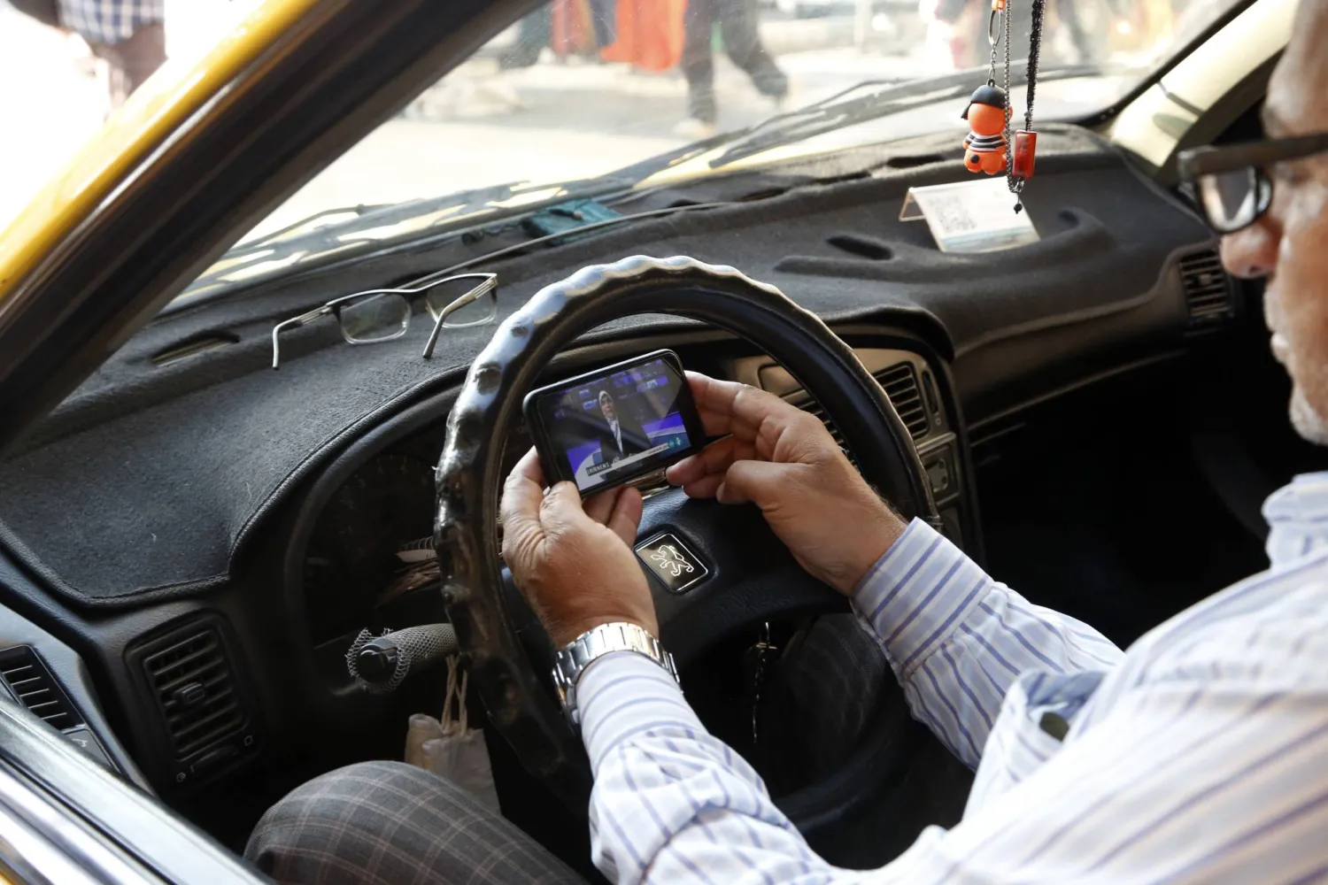 إيرانيون يتابعون أخبار فقدان مروحية الرئيس الإيراني إبراهيم رئيسي بعد تعرضها لحادث (إ.ب.أ)