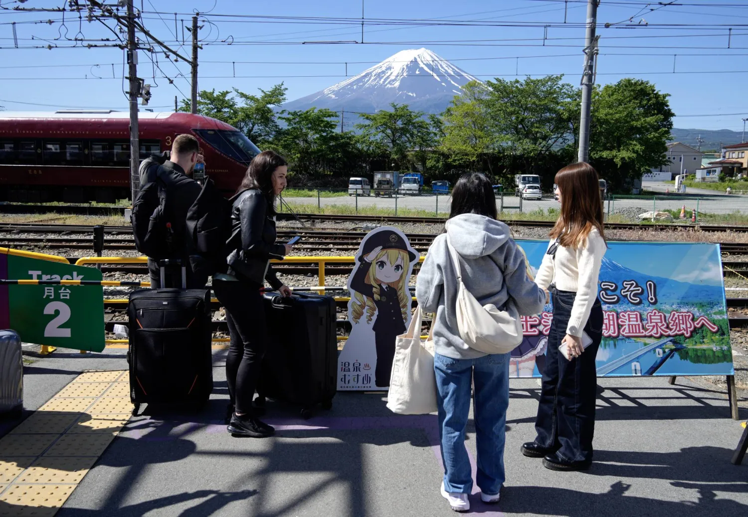 سائحون يصلون إلى محطة بالقرب من سفح جبل فوجي في اليابان (إ.ب.أ)