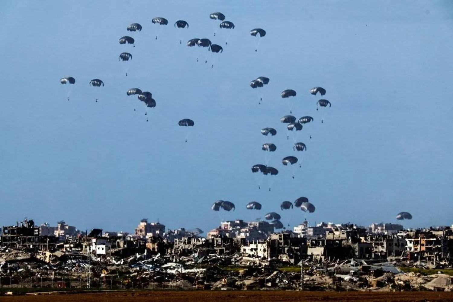 Packages fall towards northern Gaza, after being dropped from a military aircraft, amid the ongoing conflict between Israel and the Palestinian group Hamas, as seen from Israel's border with Gaza in southern Israel March 7, 2024. (Reuters)
