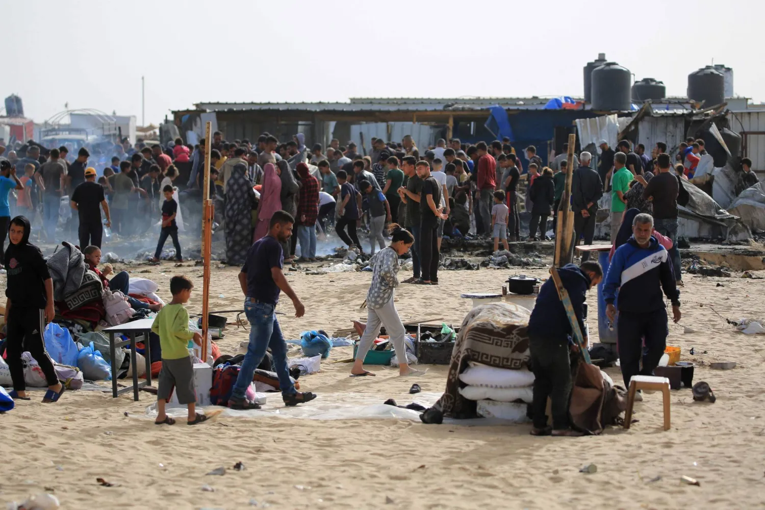 فلسطينيون يتجمعون في موقع غارة إسرائيلية على مخيم للنازحين في تل السلطان في رفح (أ.ف.ب)