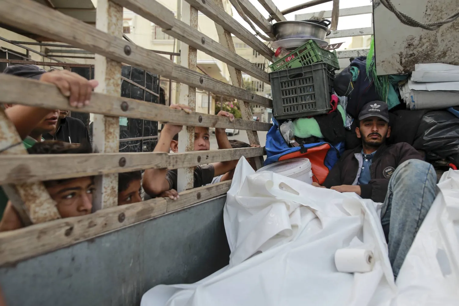 فلسطينيون في مشرحة برفح يبكون بجانب جثث أقاربهم الذين قتلوا في غارة جوية إسرائيلية (أ.ب)