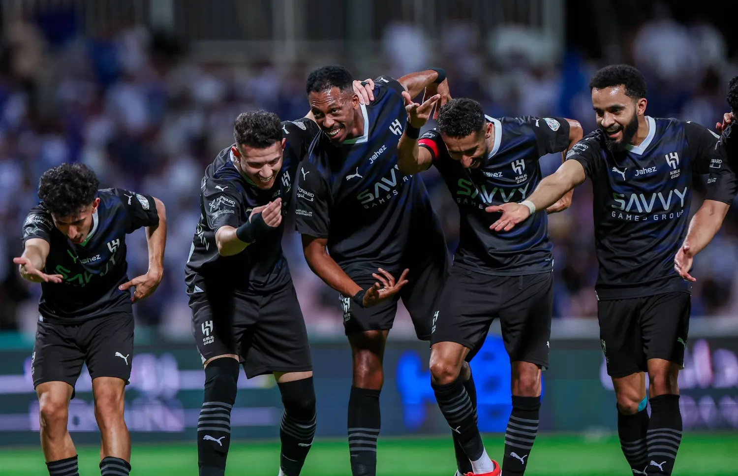 فرحة لاعبي الهلال على طريقة زميلهم محمد كنو صاحب الهدف الأول في مرمى الوحدة (الشرق الأوسط)