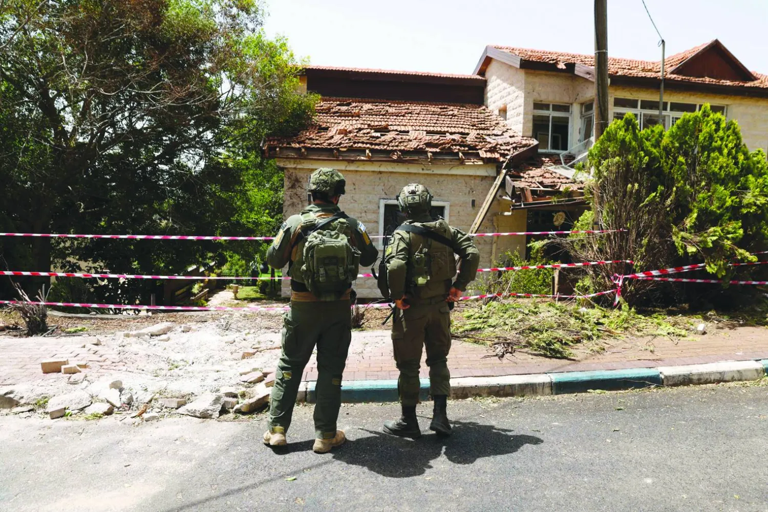 A picture taken during a tour with the Israeli army in Dovev, a Moshav in north Israel close to the border with Lebanon, shows Israeli soldiers inspecting the damage to a synagogue after it was hit by rockets fired from Lebanon on May 27, 2024. (Photo by Jalaa MAREY / AFP)