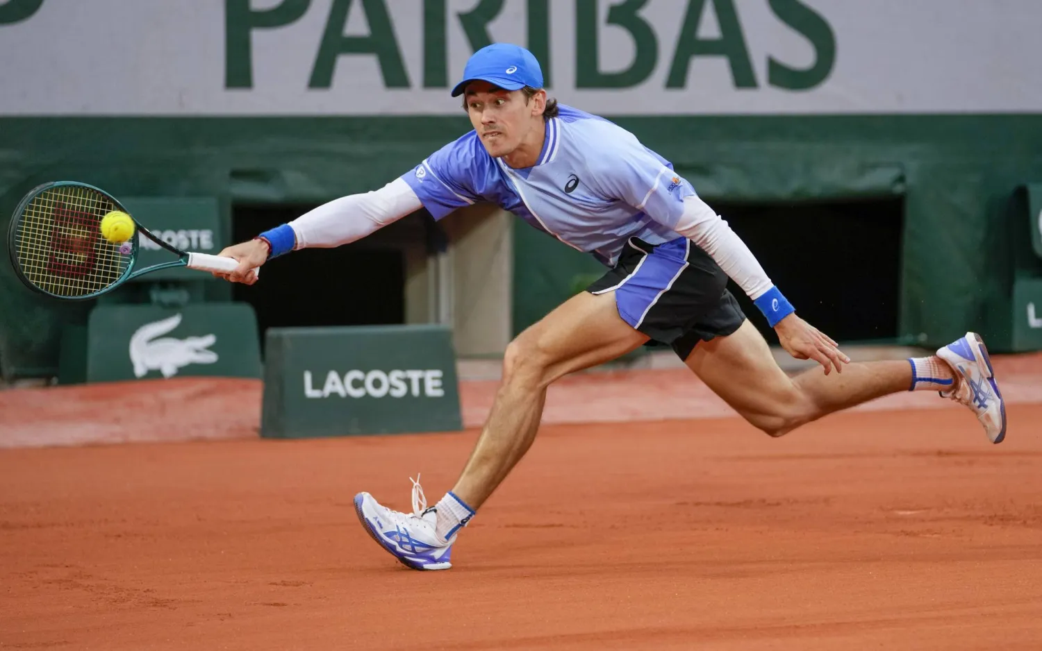 الأسترالي أليكس دي مينور خلال مواجهته الأميركي أليكس ميكلسن ضمن منافسات رولان غاروس (أ.ب)