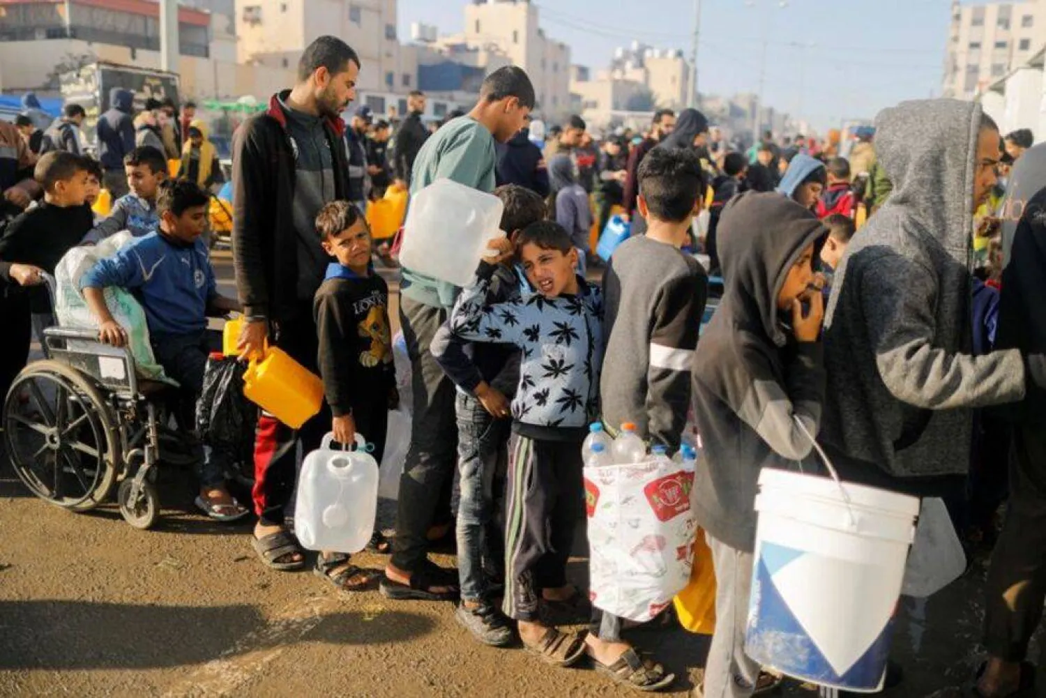 FILE PHOTO: Palestinians queue as they wait to collect drinking water, amid shortages of drinking water, as the conflict between Israel and Hamas continues, in Rafah, in the southern Gaza Strip January 4, 2024. REUTERS/Saleh Salem/File Photo