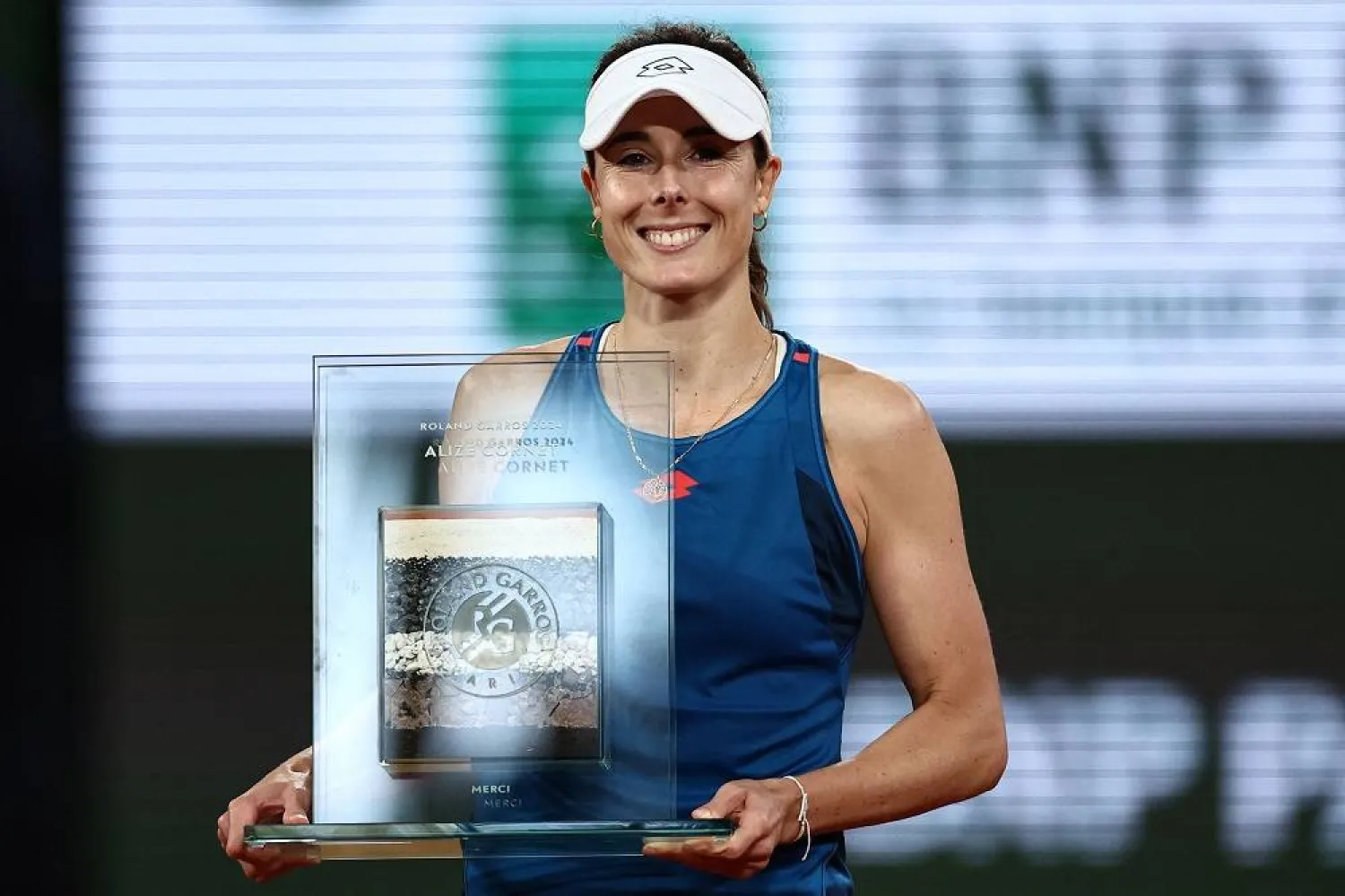 France's Alizé Cornet holds an award during a tribute ceremony after her women's singles match on Court Philippe-Chatrier against China's Zheng Qinwen on day three of the French Open tennis tournament at the Roland Garros Complex in Paris on May 28, 2024. (AFP)