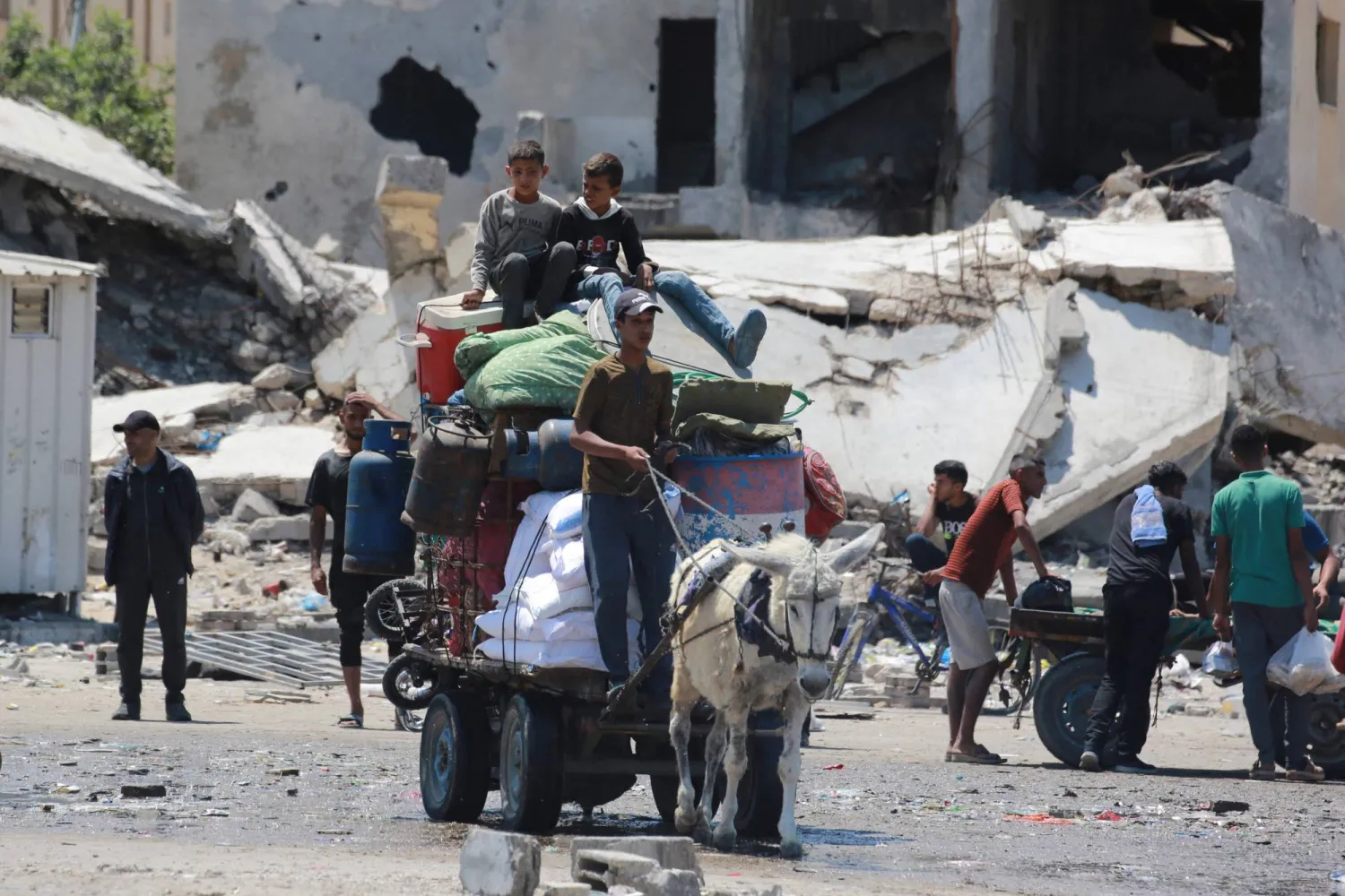 فلسطينيون يفرون بأمتعتهم من رفح بعربة يجرها حمار (أ.ف.ب)